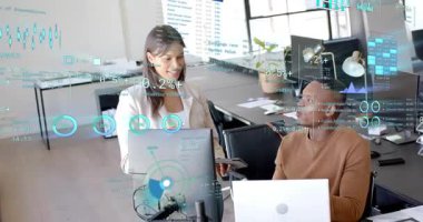 Ayakta duran kadın tableti eğip tıkırdatıyor AR finans dosyalarını masaya koyan adama rehberlik ediyor. İşbirliği, analiz, holografik, arayüz, ofis, takım çalışması, verimlilik