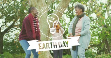 Üç nesildir aile parkta ağaç gövdesinin yanında duruyor. Çocuk yaprakları Dünya Günü grafiğiyle fırlatıyor. Çok nesilli, doğa, sonbahar, yeşillik, yaşam tarzı, birlik