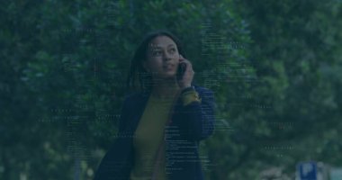 Park kaldırımında akıllı telefondan konuşan orta yaşlı bir kadın, denizci ceketi, kod örtüsü. Açık hava, yeşillik, kentsel, profesyonel, çağrı, cep telefonu, teknoloji