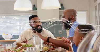 Çatal yemek tutan sakallı adam ve aile reaksiyonu yapan kel adam sol kaplama süpürme işlemi yapıyor. Çok nesilli, akşam yemeği, masa, yakınlık, kahkaha, akrabalar, sıcaklık.