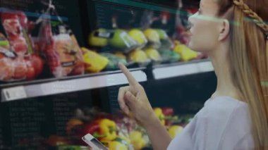 Kadın telefonlarını dinliyor, market koridorundaki ürünlere bakıyor, ışık çizgileri yol gösterici seçimler yapıyor. Alışveriş, akıllı telefon, biber, sebze, raf, süpermarket, perakende