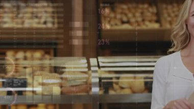 Çerçeveye giren, kart yükselten ve fırında ekmek tutan bir kadın. Satışları gösteren kartlar üzerinde çizelgeler. Ekmek, alışveriş, perakende, ekran, sayaç, grafikler, veriler