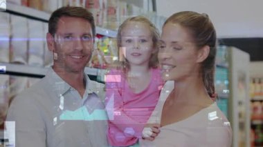 Aile market koridorunda poz veriyor, kameraya cevap veriyor, çocuğu kucağına alıyor ve el sallıyor, el sallıyor. Ebeveynler, kızlar, alışveriş, süpermarket, perakende, kaplama, grafikler