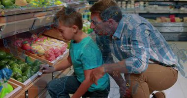 Baba ve oğul marketten avokado seçiyor, baba işaret ediyor, oğul alışveriş için HUD kaplamalarını kontrol ediyor. Baba, oğul, pazar, üretim, yeşil, meyve, rehberlik