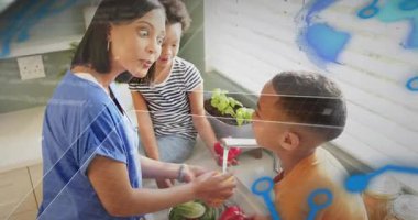 Anne çocuğa biber uzatıyor, lavaboda durulanıyor, yemek hazırlıyor ve mavi kaplamalar ortaya çıkıyor. Aile, sebze, yemek, ev, güneş ışığı, kahkaha, işbirliği