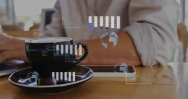 İş analizi için yazarken bardakların ve klavyelerin üzerinde süzülen çizelgelere tepki veren bir adam. Laptop, uzaktan kumanda, birlikte çalışma, kafe, kahve, gün ışığı, analitik