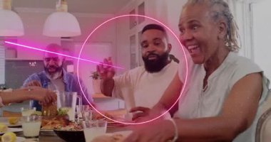 Kıdemli kadın gülüyor ve uzanıyor, aile yemeğini paylaşırken işaret eden neon kıvılcımlar saçıyor. Çok nesilli, yemek, masa, mutfak, ev, sıcak, birlikte