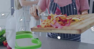 Tahtayı eğen, sebze kabuklarını gübre haline getiren, ekolojik istatistikleri gösteren bir kadın. Mutfak, çift, ev aşçısı, bıçak, kırıntı, tezgah, önlük.