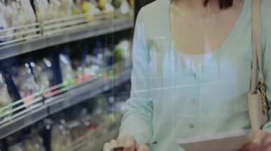 Kadın müşteri danışma listesi, el arabasını itme, rafları finansal haritalar olarak tarama. Kadın, market, koridor, buzdolabı, kalem, notlar, grafik