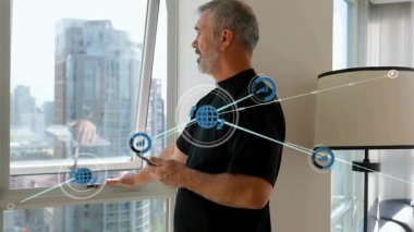 Orta yaşlı bir adam akıllı telefonu dinliyor ve pencereye işaret veriyor. Teknoloji ağı kaplamasını gözünde canlandırıyor. Holografik, ağ, düğümler, telefon, yükseklik, ufuk çizgisi, daire