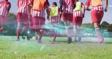 Yedi erkek futbolcu talime başlıyor ve lens fişekleri kramponları aydınlatırken sahada koşuyor. Takım arkadaşları, alan, açık hava, eğitim, kondisyon, hareket, arka plan