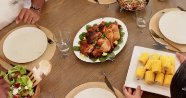 Aile elleri mısır yerleştiriyor, salata dağıtıyor ve aile yemeği için kase dağıtıyor. Yıldızlar sürüklenirken. Genel giderler, yemek, masa üstü, ahşap, tavuk, tabak, sofra takımı.