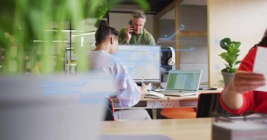 Kağıtları dağıtan kırmızı meslektaşına doğru dönen bir kadın, teknik kaplamanın ortasında onay için imza atıyor. İşbirliği, takım çalışması, belgeler, imzalar, masa, monitör, dizüstü bilgisayar