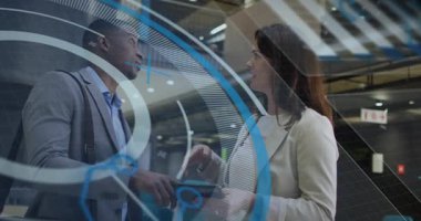 Tabletli bir adam geldi, kadın iş avlusunda ekranı tıkırdatıyor, mavi HUD verileri gösteriyor, hizalanıyor. İşbirliği, meslektaşlar, toplantı, tartışma, jest, aygıt, eşleştirme