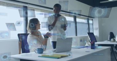 Ofisteki kadın verileri açıklıyor ve akran dinlerken dizüstü bilgisayara el kol hareketi yaparak yapay zekayı etkinleştiriyor. İkili, meslektaşlar, gün ışığı, çalışma masası, masa, kupa, tartışma