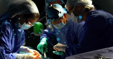 Ameliyathane ekibi örtü takmaya başlıyor, araçları geçiyor, hastayı tedavi ederken mavi kilit kaplama ekibi hazırlanıyor. Ameliyat, ameliyat, steril, önlük, far, hoparlör, enstrümanlar.