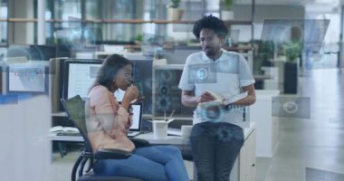 Kadın bardaktan yudumlarken, erkek planlamacı ekranın soluklaşması üzerine iş için teknolojik örtüler kuruyor. Ofis, iş arkadaşları, işbirliği, holografik, veri, modern, açık plan