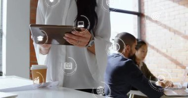 Tableti tıkırdatan, dizüstü bilgisayarların ve kadınların üzerinden İHD rozetleri yapan, iş güncel bilgilerini paylaşan bir kadın. İşbirliği, birlikte çalışma, gün ışığı, pencere, ofis, arayüz, gösterge panelleri