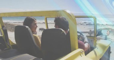 Kadın yolcu, erkek sürücüye dönüyor. Sürücü, sarı Jeep 'le okyanusa doğru hareket ediyor. Çift, araba, yaşam tarzı, güneş ışığı, sahil, deniz kenarı, üstü açılabilir.