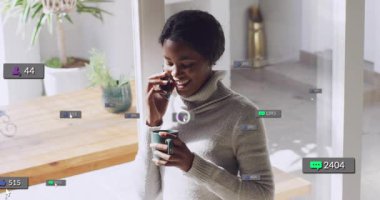 Mutfakta telefonla konuşan bir kadın, hareketli sosyal uyarılar patlıyor, onu güldürüyor ve yudumluyor. Parlak, iç mekan, yemek, çağdaş, bitki, fincan, aygıt