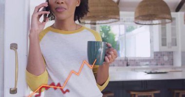 Eğilip, telefon tutan, telefon eden, telefon eden, para ve gövdeyi kaplayan grafiklerden bahseden bir kadın. Mutfak, kupa, deniz mavisi, gün ışığı, rahat, rahat, gülümse.