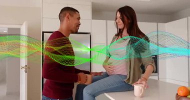 Bekleyen bir çift, mutfaktan geçerken göbeğine dokunarak sıhhatlerini temizliyor. Hamile, anne-baba, şefkat, şefkat, tezgah, fincanlar, ev