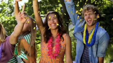 Arkadaşlar parkta durup, silah doğrultup, altın konfeti yağmuruna neden oluyorlar. Toplanma, kutlama, açık hava, şenlik, neşe, birliktelik, samimiyet