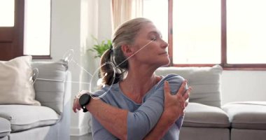 Kadın omuz rutinini, kollarını sararak ve sağlık için esneyerek, düğümleri takip ederek başlatıyor. Son sınıf, ev, kanepe, güneş ışığı, boyun, gövde, egzersiz