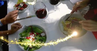 Dört lokantacı, beyaz masa altın patikasında yiyeceği paylaşıyor ve bardakların arasından sağ iplik çıkıyor. Düzlük, yemek, salata, makarna, şarap, veranda, genel giderler