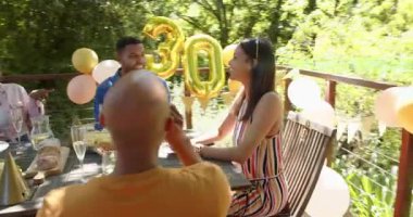 Dört arkadaş mavi gömlekli doğum gününden sonra el çırpıyor, altın rengi 30, yeşil işaret fişeği saklayan yüzler, olaylar. Kutlama, arka bahçe, güverte, balonlar, pastel, dekor, kahkaha