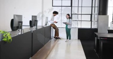 Erkek ve bayan meslektaşlar tablet gösteriyor, çıkıntıyı itiyor ve yürüyor, ofis planını gözden geçiriyorlar. İşbirliği, takım çalışması, tartışma, birlikte çalışma, aygıtlar, monitörler, gün ışığı