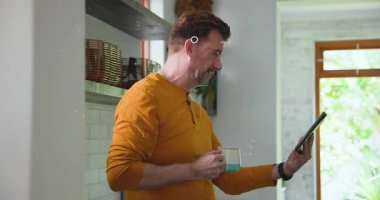 Yetişkin adam mutfakta tablet kaldırıyor ve tıkırdatıyor, güvenlik için devre ve asma kilit sahnesini aktifleştiriyor. Siber güvenlik, gizlilik, şifreleme, etkileşim, dijital, modern, minimalist