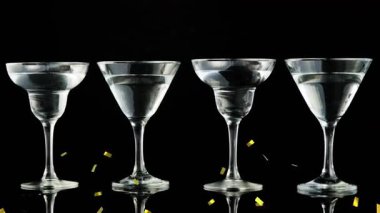 Konfeti düşüyor, zeytinler martini bardaklarına dökülüyor, sıçrama ve taşma hareketlerine neden oluyor. Cam, kokteyl, yansıtıcı, saplı, yeşil, masa üstü, minimalist