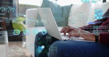 Kadın daktilo ediyor, kucakta kayıyor, finansmanı kontrol ediyor HUD çizelgeleri ve kamera geri çekiliyor. Laptop, uzaktan kumanda, veriler, analizler, ev, kanepe