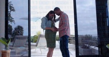 Erkek yaklaşır, hamile kadın şişliğe dokunur eğilir, cama yapıştırır ve sağlığını gösterir. Romantizm, şefkat, çift, sahil, güverte, deniz manzarası, bulutlu