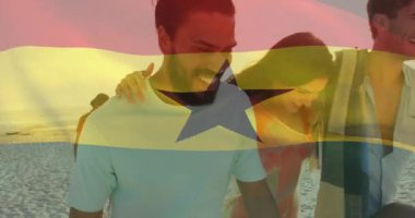 Dostlar gün batımında kumsalda yürümeye başlıyor, dördüncü katılımda bayrak dalgalanması ve renkli seyahat reklamı. Grup, kıyı, alacakaranlık, sinema, boş zaman, gündelik, deniz kenarı