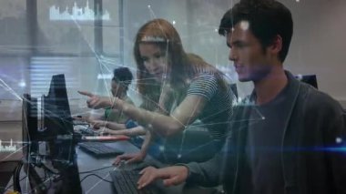 Bir kadın teknoloji laboratuvarında monitörü gösteren adama eğiliyor, çizelgeleri işaretleyen düğümlere rehberlik ediyor. İşbirliği, sınıf, bilgisayar, danışmanlık, eğitim, veri, görselleştirme