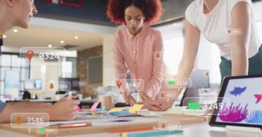 Üç kadın telefon gruplama notlarını tasarım kümelerine yerleştirip masanın etrafında alarm olarak planlıyorlar. İşbirliği, fikir, açılış planı, gün ışığı, stüdyo, tablet, kalemler