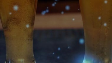 Kamera, ayrıntıları göstermek için iki uzun bira bardağının köpürdüğünü gösteriyor. Pilsner, amber, karbonat, yoğunlaşma, mavi, bokeh, bar