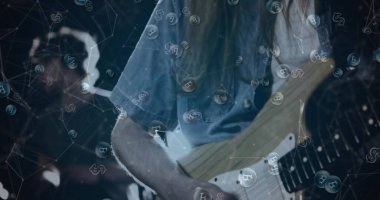 Soluk kot gömlekli gitarist loş sahnede Bitcoin baloncuklarıyla elektro gitar çalıyor. Müzik, ikili, enstrüman, teller, prova, ışıklandırma, şifreleme