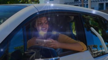 Kadın sürücü koltuğunda oturmuş telefon okuyor, gülümsüyor cam boyunca teknoloji yıldızlarına neden oluyor, sosyal yardım için selfie çekiyor. Araba, kentsel, güneşli, aygıt, ön cam, takımyıldız, yansımalar