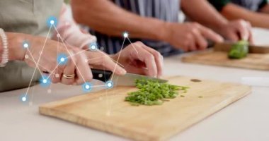 Katılımcı bıçağı alıyor, tarifi hazırlamak için uçakta otlar kesiyor, mavi düğümler iz sürme hareketi yapıyor. Mutfak, yemek pişirme, grup, önlük, sebze, tezgah.