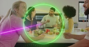 Adam ocakta yemek pişirmeye başlar, arkadaşlar kâse geçirir ve tatma yapar, neon kaplamalar paylaşılmış yemeği çerçeveler. Mutfak, ada, toplanma, neşeli, modern, güneşli, sosyal