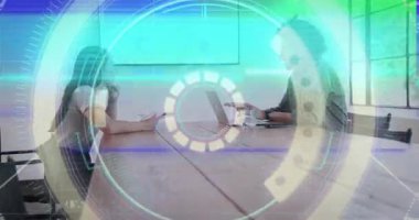 Woman tapping tablet and activating circular HUD, colleagues analyzing laptop charts for business. Office, boardroom, meeting, collaboration, futuristic, technology, digital