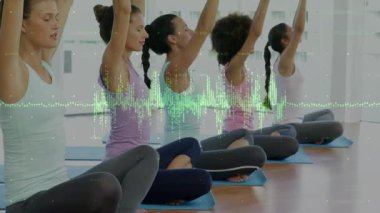 Yoga dersinde beş kadın yeşil dalga formunu takip ediyor, nefes almak için kollarını kaldırıyor. Grup, fitness, sağlık, odaklanma, sakinlik, duruş, stüdyo