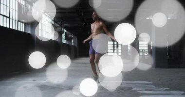 Adam depoda ip atlama antrenmanına başlıyor, bokeh yanlama yapıyor, onu gizliyor. Sanayi, atlama, halat, atlet, beton, pencere, sütun