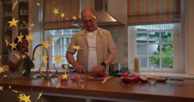 Kadın yeşil önlükle adaya girip çıkarken, adam adaya saldırıyor, yemek pişirmeye yardım ediyor, yıldızları örtüyor. Mutfak, çift, ada, ev, sebze, biber, domates