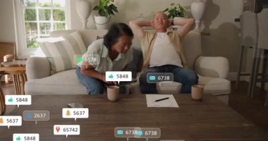 Kadın tableti alıp tıkırdatıyor, teknik demo için çiftlerin etrafında yüzen ihbarlar yapıyor. Ev, oturma odası, partnerler, aygıt, etkileşim, gün ışığı, rahat