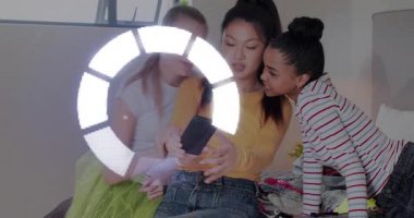 Sosyal içerik için orta gençlik telefonu dinleme, arkadaşlar öne eğiliyor, yüzleri çevreleyen dairesel örtüler. Üçlü, yatak odası, rahat, rahat, kahkaha, gençlik, cep telefonu