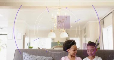 Kamera, kardeşlerin kanepeye oturduğunu, oğlanın tableti tıkladığını, kızın tableti tuttuğunu, HUD 'nin eğitimi gösterdiğini gösteriyor. Çocuklar, oyun zamanı, ekran, işbirliği, öğrenme, parlak, modern